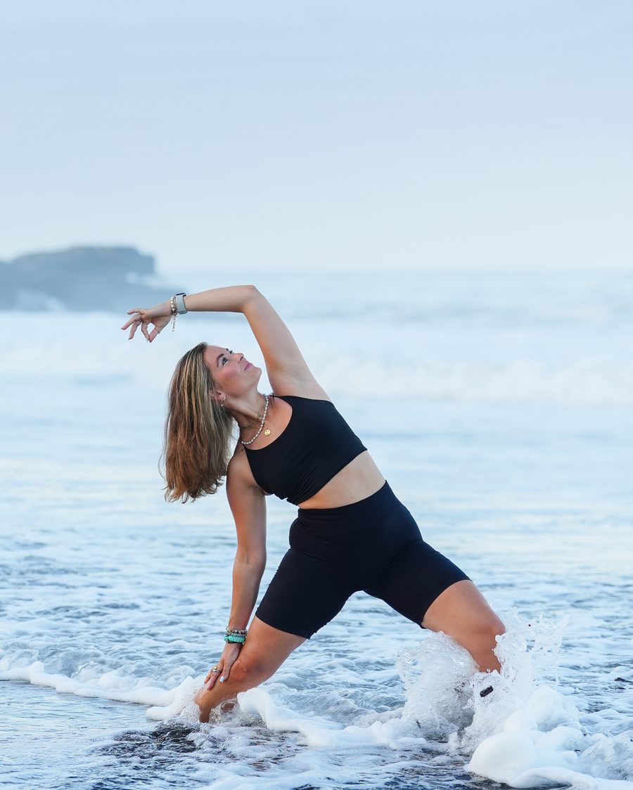 Lina Kunze in einer Yoga-Haltung am Meer